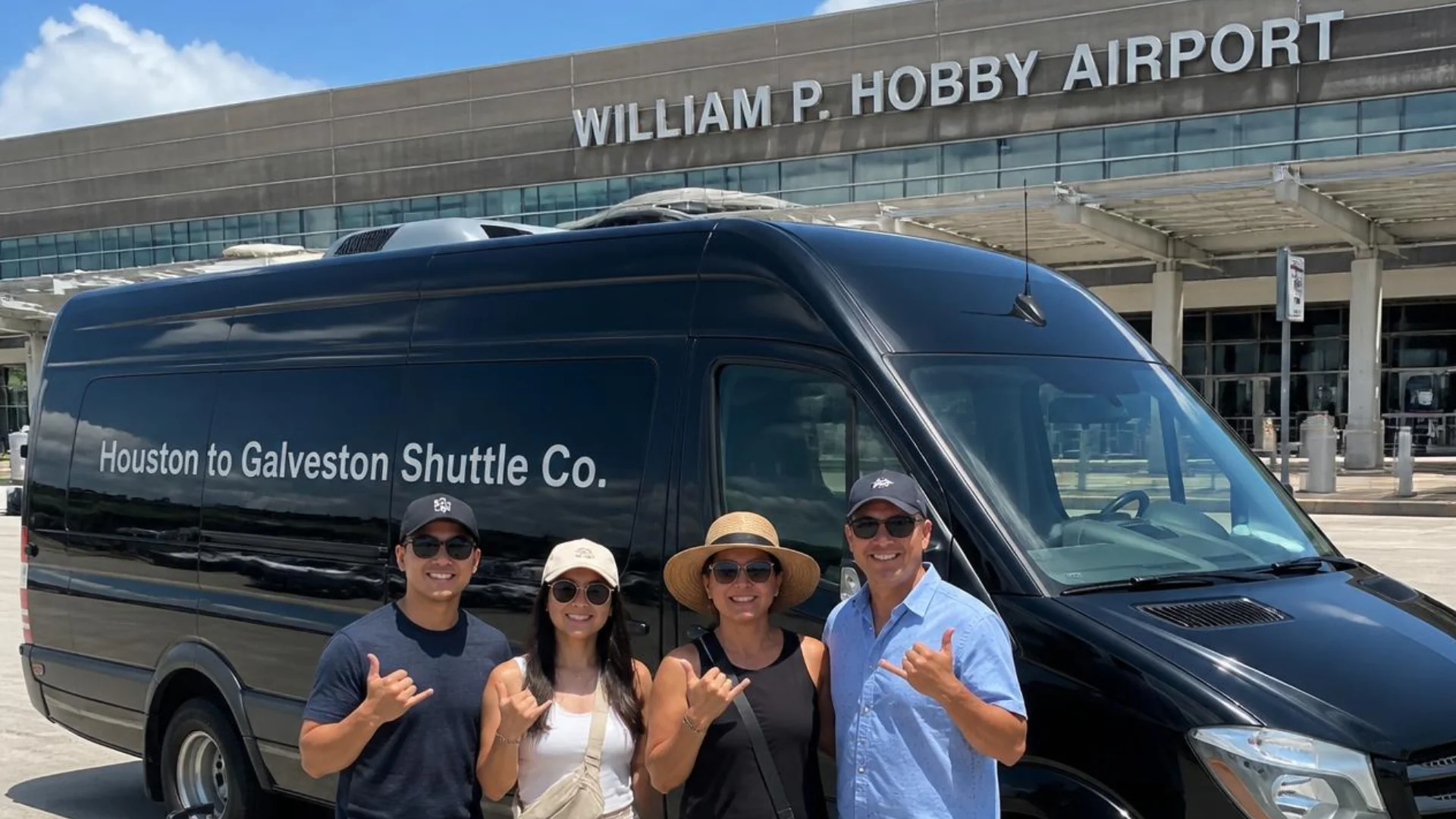 Passengers beside a Houston to Galveston Shuttle Co. black Sprinter van at William P. Hobby Airport